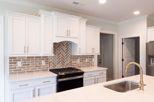 kitchen featuring ornamental molding, sink, appliances with stainless steel finishes, and white cabinets