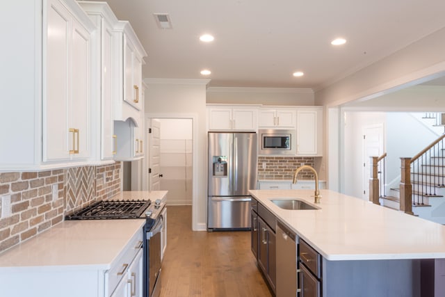 kitchen with white cabinetry, backsplash, stainless steel appliances, and sink