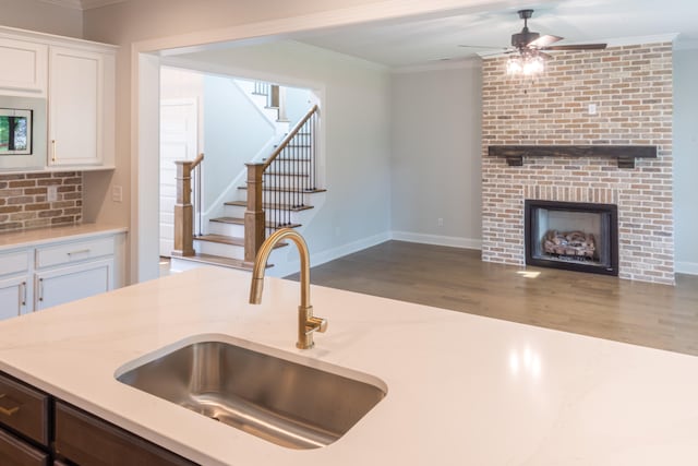 kitchen featuring crown molding, white cabinetry, and sink