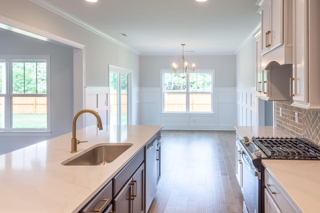 kitchen with appliances with stainless steel finishes, plenty of natural light, sink, and light stone counters