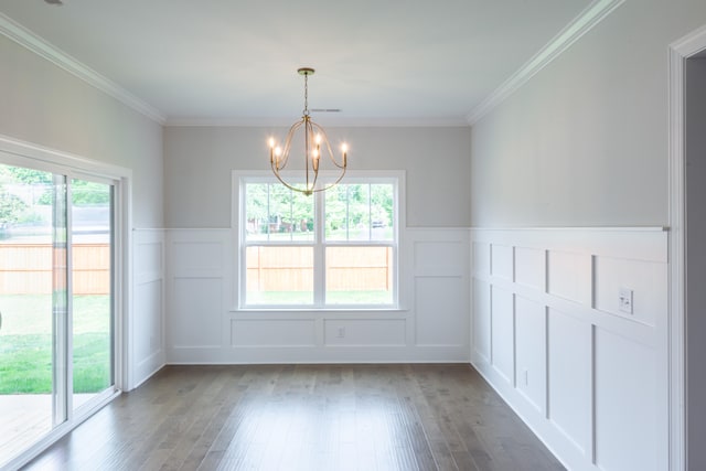 unfurnished dining area with ornamental molding, dark wood-type flooring, and an inviting chandelier