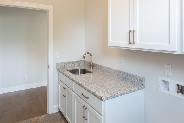 kitchen featuring light stone countertops, sink, white cabinets, and dark hardwood / wood-style floors