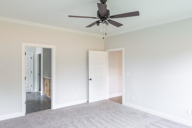 unfurnished bedroom featuring ceiling fan, crown molding, and dark carpet