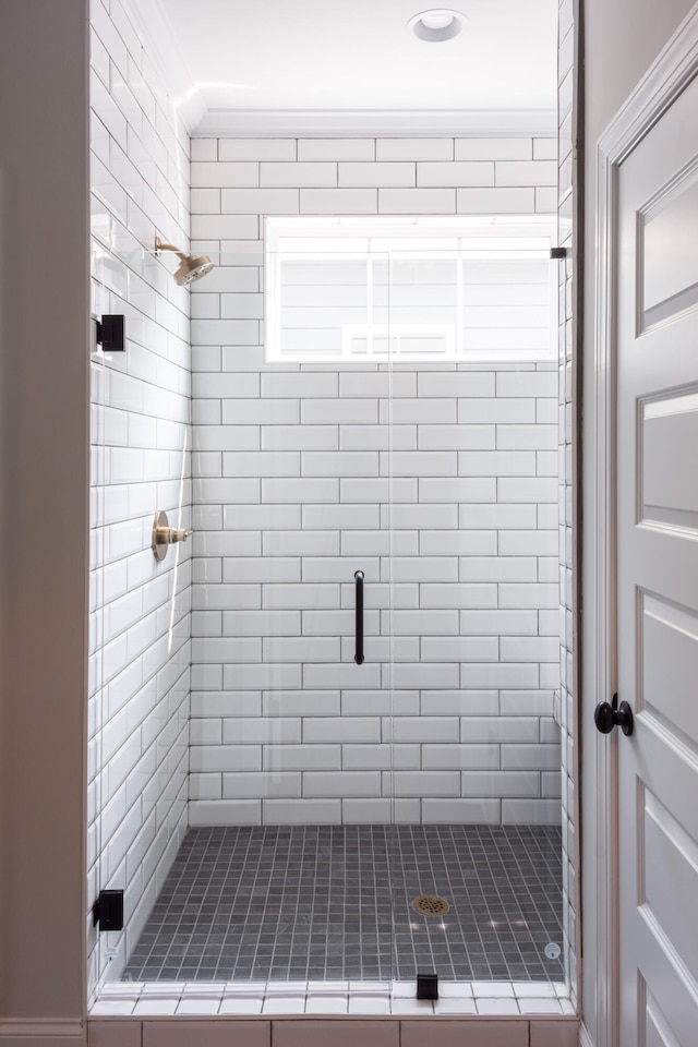 bathroom with crown molding and walk in shower