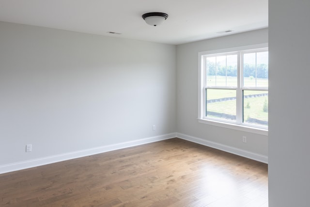 unfurnished room with hardwood / wood-style flooring