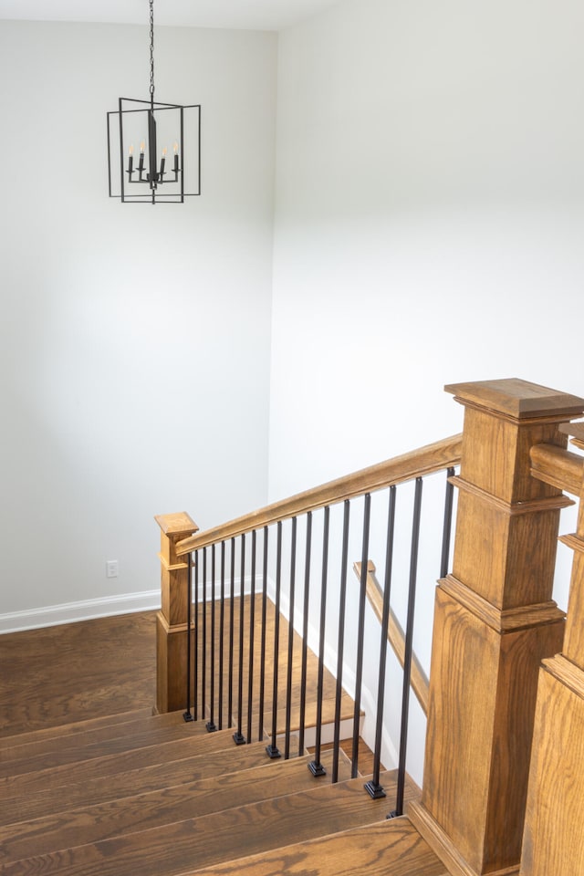 stairs featuring a chandelier and wood-type flooring