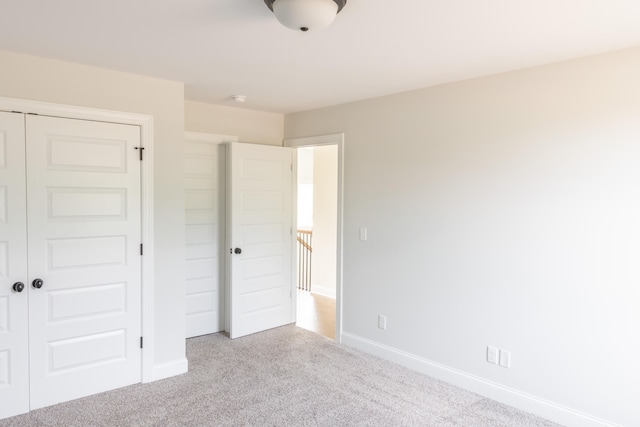 unfurnished bedroom featuring a closet and light carpet