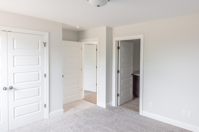 unfurnished bedroom featuring light colored carpet and a closet