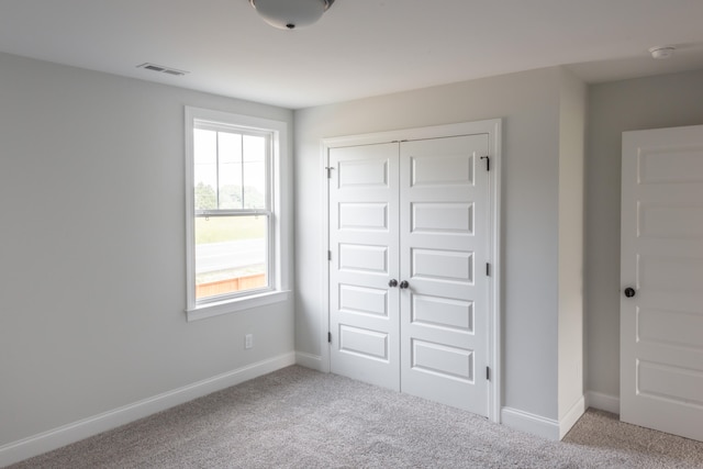 unfurnished bedroom featuring a closet and light carpet