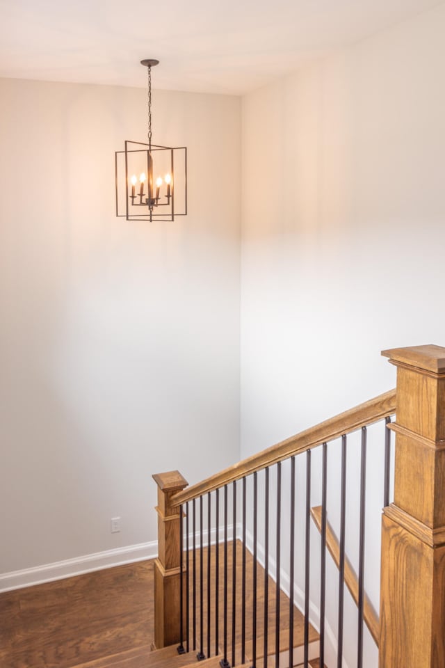 staircase featuring hardwood / wood-style flooring and a chandelier