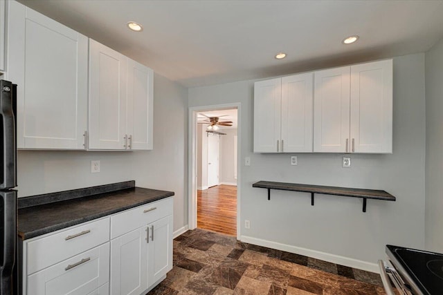 kitchen with white cabinets, range, ceiling fan, and stainless steel refrigerator