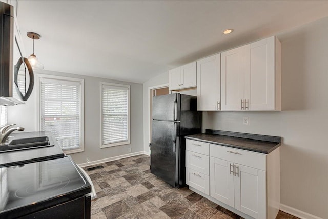 kitchen featuring stainless steel appliances, pendant lighting, vaulted ceiling, sink, and white cabinetry