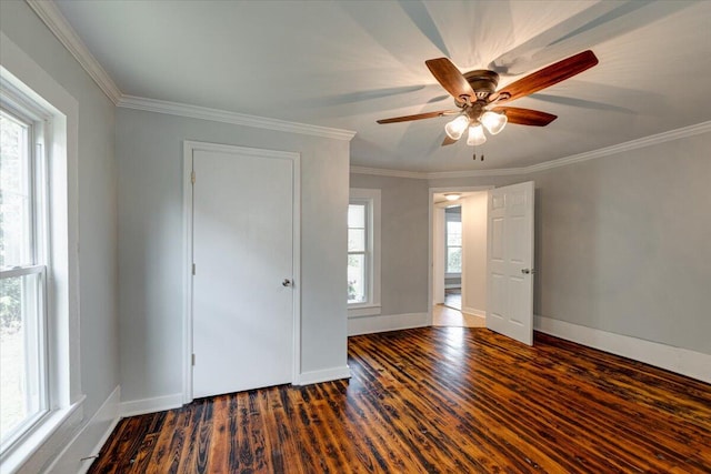 spare room with dark wood-type flooring, ceiling fan, and crown molding