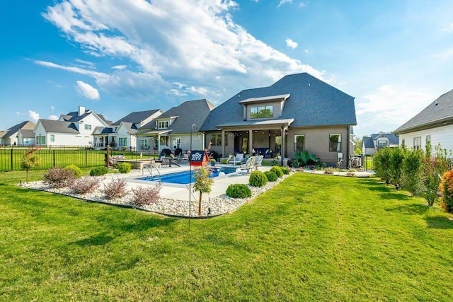 back of house with a lawn, a patio, and a fenced in pool