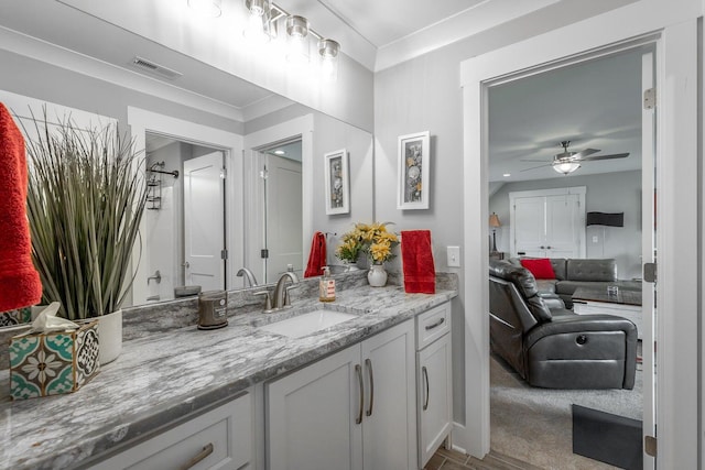 bathroom with ceiling fan, vanity, and ornamental molding