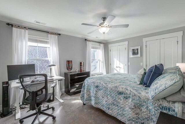 bedroom featuring ornamental molding, light carpet, ceiling fan, and multiple closets