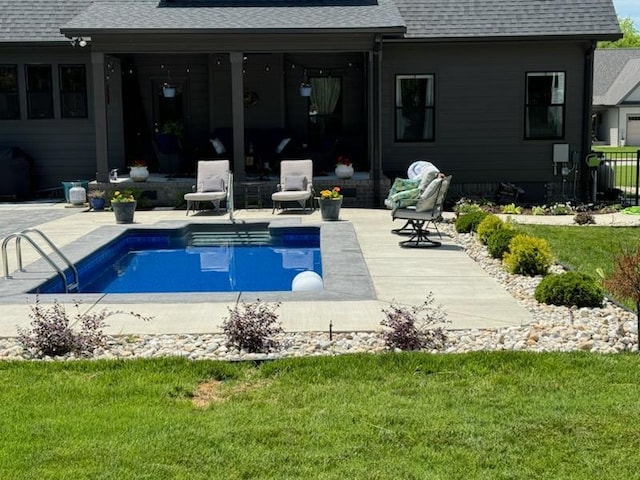 view of pool with a lawn and a patio area