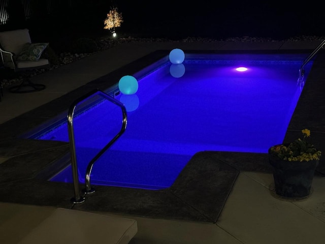 view of pool at twilight