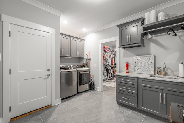 kitchen with light tile patterned floors, sink, gray cabinetry, washer and clothes dryer, and crown molding