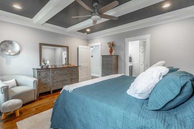 bedroom with beamed ceiling, ensuite bathroom, dark hardwood / wood-style flooring, ornamental molding, and ceiling fan