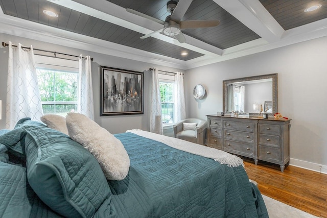 bedroom with ceiling fan, beamed ceiling, hardwood / wood-style flooring, and multiple windows