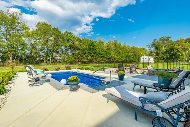 view of pool with a lawn and a patio