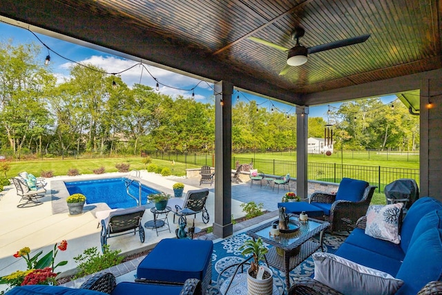 view of swimming pool featuring ceiling fan, outdoor lounge area, a lawn, and a patio