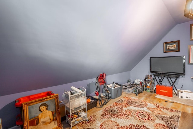 recreation room with hardwood / wood-style flooring and lofted ceiling