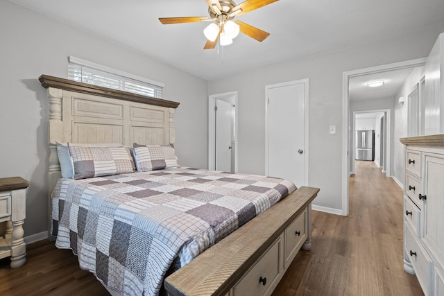 bedroom with stainless steel fridge, ceiling fan, and dark wood-type flooring