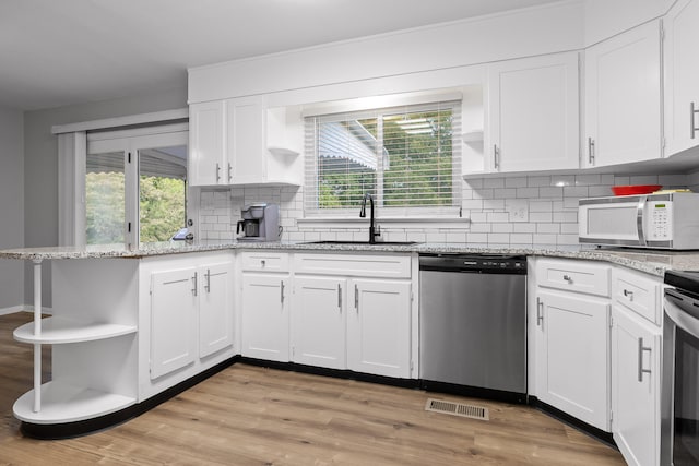 kitchen with white cabinets, appliances with stainless steel finishes, plenty of natural light, and light wood-type flooring