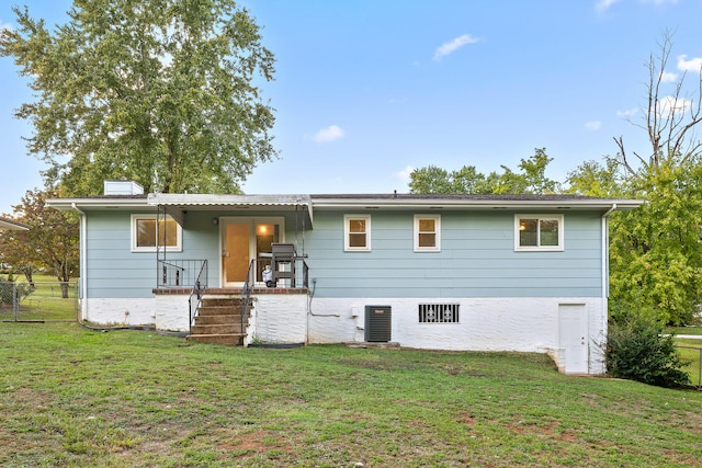 rear view of property with a yard and central air condition unit