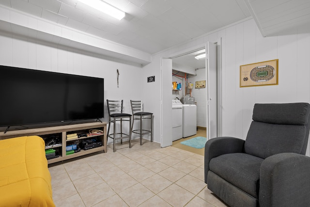 tiled living room with wooden walls and washer and clothes dryer