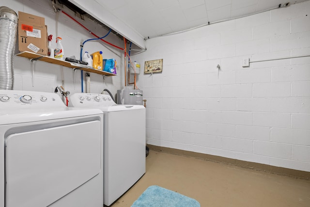 washroom featuring water heater and washing machine and dryer