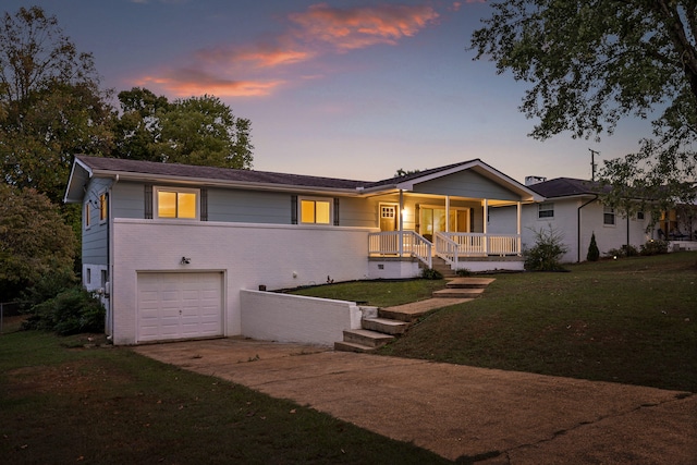 view of front facade featuring a garage, a yard, and covered porch