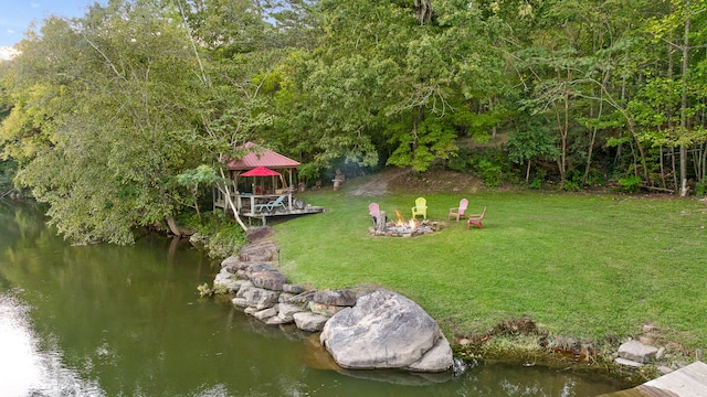 view of yard with a water view and an outdoor fire pit