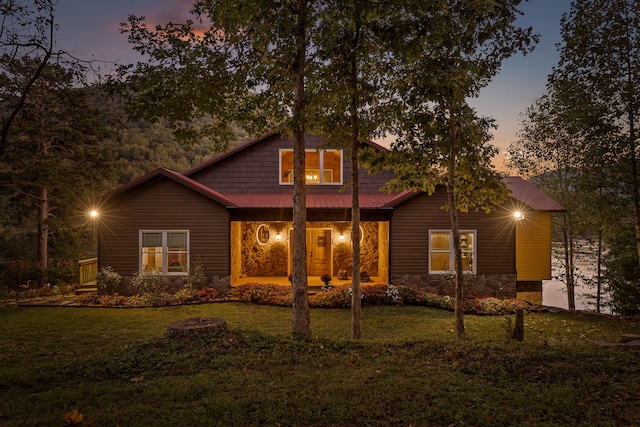 back house at dusk featuring a yard