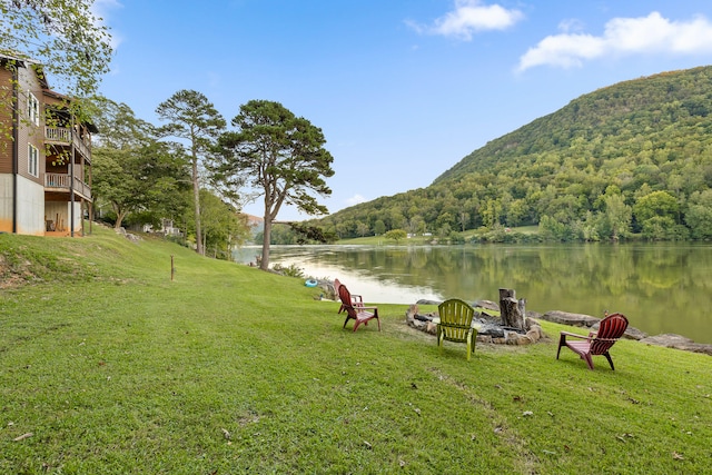 view of home's community featuring an outdoor fire pit, a yard, and a water and mountain view