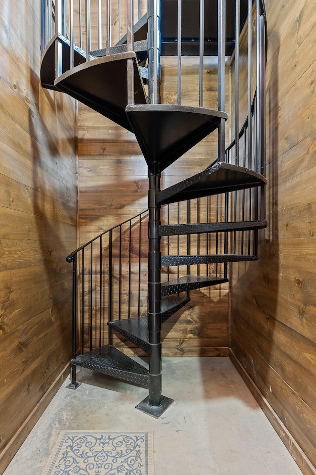 stairway with wooden walls and concrete flooring