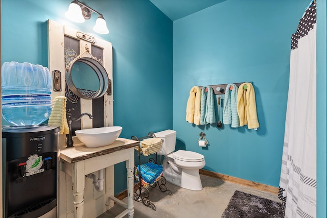 bathroom with concrete floors, sink, and toilet