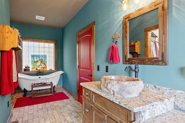 bathroom featuring a washtub and vanity