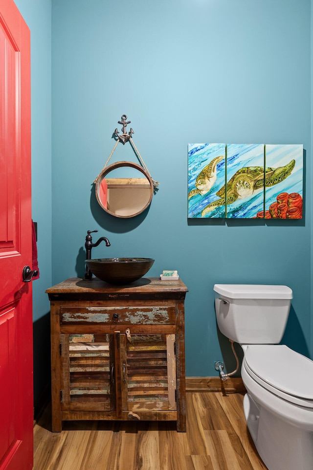 bathroom with hardwood / wood-style floors, vanity, and toilet