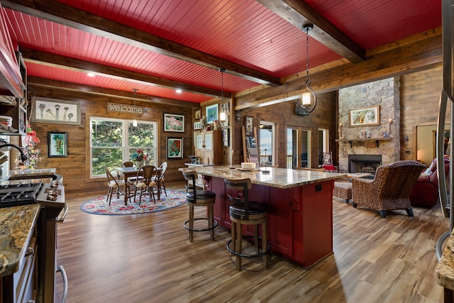 kitchen with wood-type flooring, pendant lighting, wood walls, and high end range