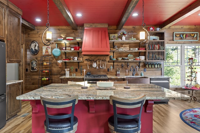 kitchen with light wood-type flooring, hanging light fixtures, and a spacious island