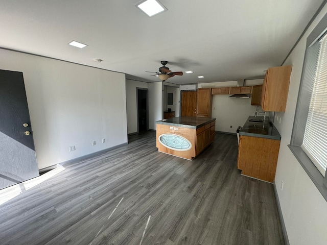 kitchen with a kitchen island, dark wood-type flooring, and ceiling fan