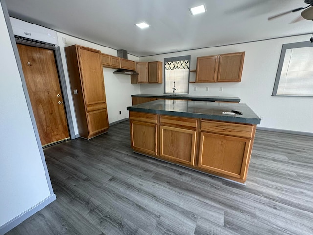 kitchen featuring ceiling fan, a center island, dark hardwood / wood-style floors, and sink