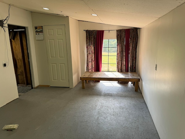 unfurnished room with a textured ceiling and lofted ceiling