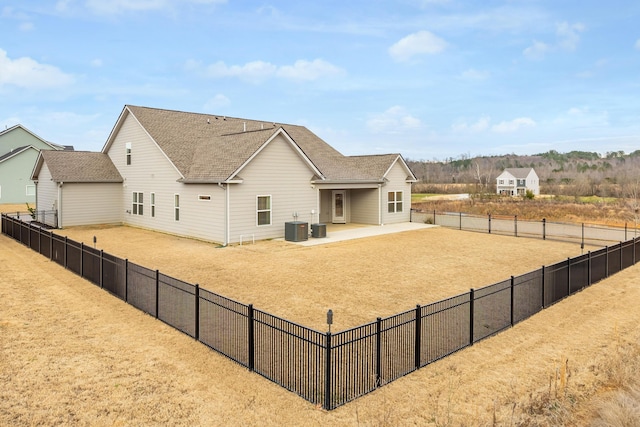 back of property with central air condition unit and a patio area