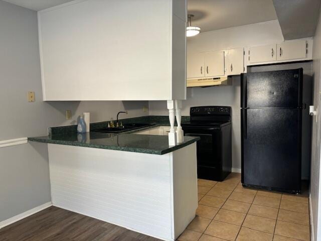 kitchen with light hardwood / wood-style floors, sink, white cabinets, kitchen peninsula, and black appliances