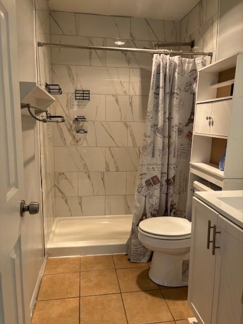 bathroom featuring a shower with shower curtain, tile patterned flooring, vanity, and toilet