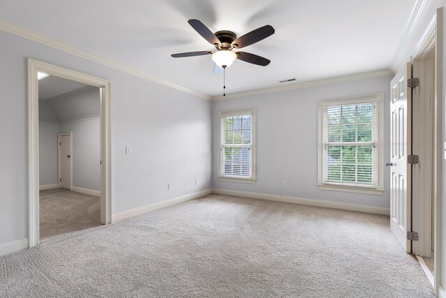 carpeted spare room featuring ceiling fan, crown molding, and a healthy amount of sunlight